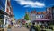 Beautiful shopping street, typical colorful old dutch houses, exterior cafes and restaurants, blue summer sky