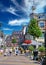 Beautiful shopping street, typical colorful old dutch houses, exterior cafes and restaurants, blue summer sky