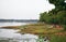 Beautiful shore near a lake with green fields touching water and boat standing