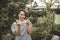 A beautiful short haired asian woman wearing an off shoulder top makes finger heart gestures. Summer outfit