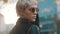 Beautiful short haired blond woman in leather jacket and sunglasses turning her head toward camera