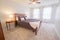 Beautiful shot of a bedroom with a double size bed, lamp on the table and a ceiling fan