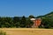 Beautiful shot of a bricked building surrounded  with trees from the fields from a daylight