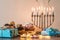 Beautiful shot of a burning Menorah lampstand next to pastry in celebration of Hanukkah