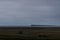 Beautiful shot of a cabin in the middle of green land by the sea on a foggy day