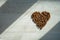 Beautiful shot of the coffee mug in the morning on the white wooden table with coffee heart shaped beans. Perfect for copy valent