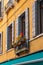 Beautiful shot of colorful flowers on a balcony of a yellow building