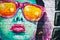 Beautiful shot of a colorful illustration of a female face with sunglasses on a wall