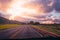 Beautiful shot of a countryside road through a vehicle with breathtaking clouds in the sky