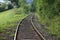 Beautiful shot of a curved railroad surround with grass and bushes