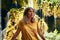 Beautiful shot of a female in a yellow shirt  posing next to a waterfall, looking up