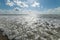 Beautiful shot of the foamy ocean under the bright calm sky - perfect shot for a desktop wallpaper