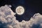 Beautiful shot of the full moon in the night sky full of stars and cumulus clouds