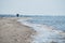 Beautiful shot of human silhouettes walking through the edge of the ocean shore