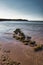 Beautiful shot of the Isle of Wight island with calm waves crashing on the sand under a blue sky