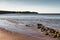 Beautiful shot of the Isle of Wight island with calm waves crashing on the sand under a blue sky