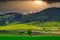 Beautiful shot of the landscape with mountains, glorious fields full of greens and cloudy sky.