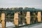 Beautiful shot of a metallic bridge leaning on concrete bases by trees on a coast