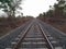 Beautiful shot from the middle of the railroad under the clear white sky