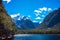 Beautiful shot of Milford Sound with the pier in the foreground and the snow capped mountains in the background taken on a sunny