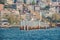 Beautiful shot of navigation channel with vertical pipes with houses near the sea on the background