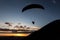 Beautiful shot of a paraglider silhouette flying over Monte Cucco Umbria, Italy and toward the sunset, with beautiful