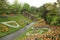 Beautiful shot of a pathway in the middle of grassy hills with flowers