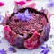 Beautiful shot of a pear raw vegan purple cake with dehydrated pears on a white tabletop - vegan