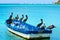 Beautiful shot of pelicans resting on a small boat in a light blue sea