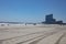 Beautiful shot of people walking on the beach shore with buildings in the distance