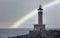 Beautiful shot of the Punta Nariga lighthouse, Galicia, Spain with a rainbow in backgroun