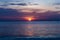Beautiful shot of the setting sun in the colorful sky above the calm ocean in