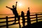 Beautiful shot of silhouettes of happy teenagers on a pier at sunset