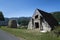 Beautiful shot of a small triangular stone barn in a rural area and the sky in the background