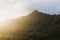 Beautiful shot of a steep mountain with the light of sunset in a cloudy sky