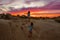 Beautiful shot of two small girls rolling down a sand slide during dramatic sunset