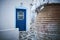 Beautiful shot of a white building with a blue door in the narrow street in Paros, Greece