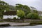 Beautiful shot of a white cottage in a valley at Ogmore Castle in South Wales on a cloudy day