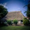 Beautiful shot of a white ranch with high roof and green garden on the foreground