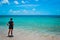 Beautiful shot of a woman standing on a sandy beach enjoying the view of the ocean