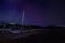 Beautiful shot of a wooden boat on the shore with a dark sky filled with stars in the background