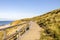 Beautiful shot of a wooden path in hills at the shore of the ocean in Sylt Island in Germany