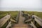 Beautiful shot of a wooden path in hills at the shore of the ocean in Sylt Island in Germany