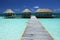 Beautiful shot of a wooden pathway to the bungalow in the shallow part of the beach of Cuba