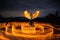 Beautiful shot of a young woman with swirling long exposure lights and wings in a forest at night