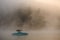 beautiful side view of bright motorboat on water covered with fog.