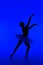 Beautiful silhouette of ballerina on blue background dancing ballet. Woman performs smooth movements. Sensual dancer in