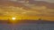 Beautiful silhouette of city by sea on background of sunset. Action. Seascape with city on coast on background of bright