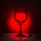 beautiful silhouette empty wine glass on red and black background, close up