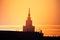 A beautiful silhouette of a tower in city during the sunrise. Morning scenery of Riga, Latvia. Tall building in city.